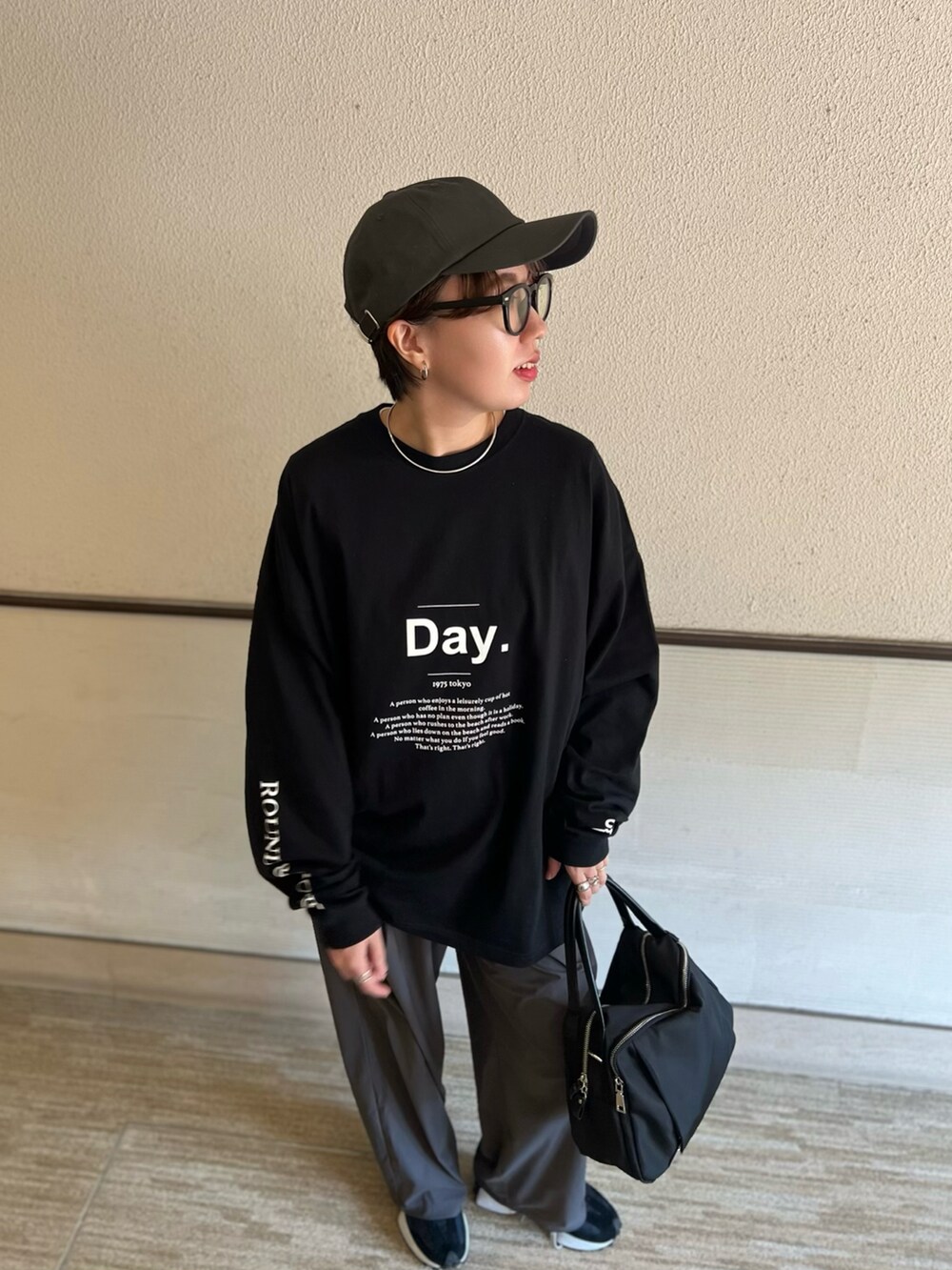 ブラック系のTシャツ/カットソー、ブラック系のスニーカーを着用したレディースの春コーディネートの2枚目の写真