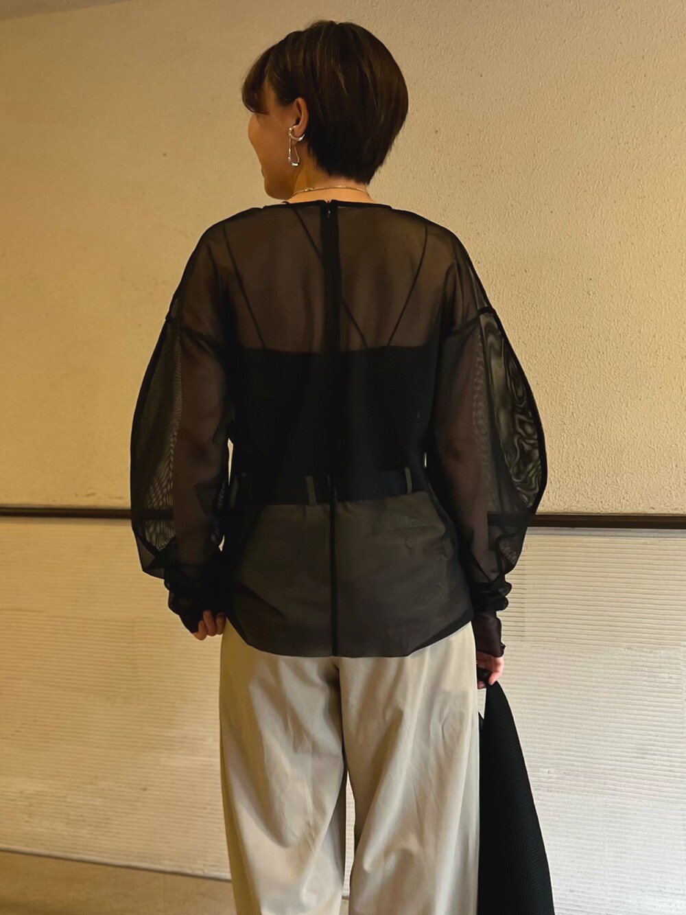 ブラック系のシャツ/ブラウス、ベージュ系のスラックス、ブラック系のハンドバッグを着用したレディースの春コーディネートの5枚目の写真