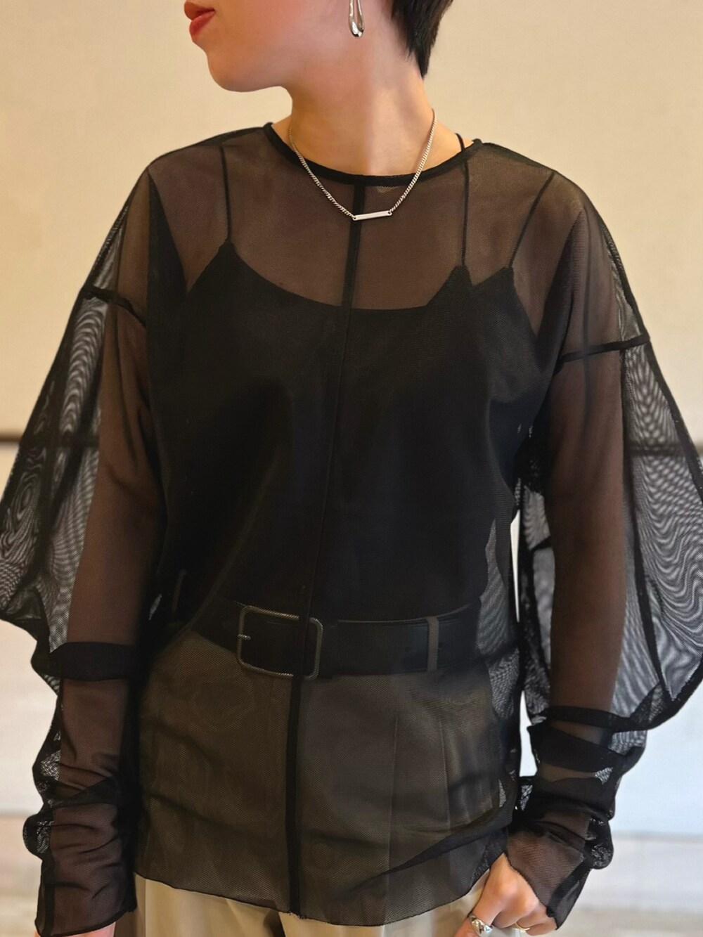 ブラック系のシャツ/ブラウス、ベージュ系のスラックス、ブラック系のハンドバッグを着用したレディースの春コーディネートの2枚目の写真