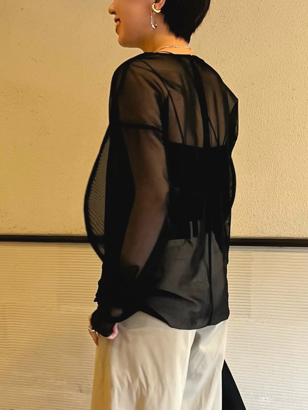 ブラック系のシャツ/ブラウス、ベージュ系のスラックス、ブラック系のハンドバッグを着用したレディースの春コーディネートの3枚目の写真