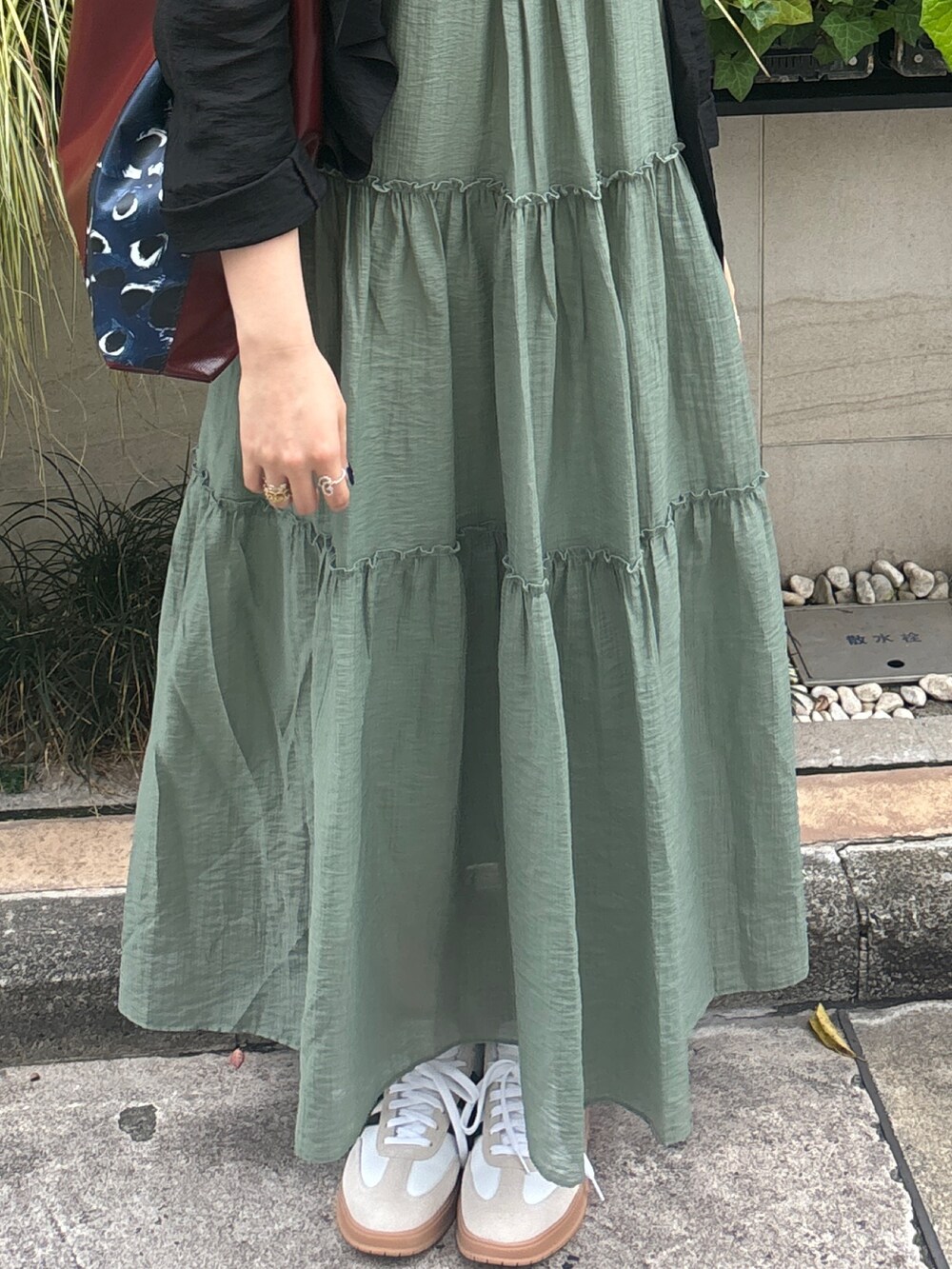 グリーン系のワンピース、ブラック系のテーラードジャケットを着用したレディースの夏コーディネートの8枚目の写真