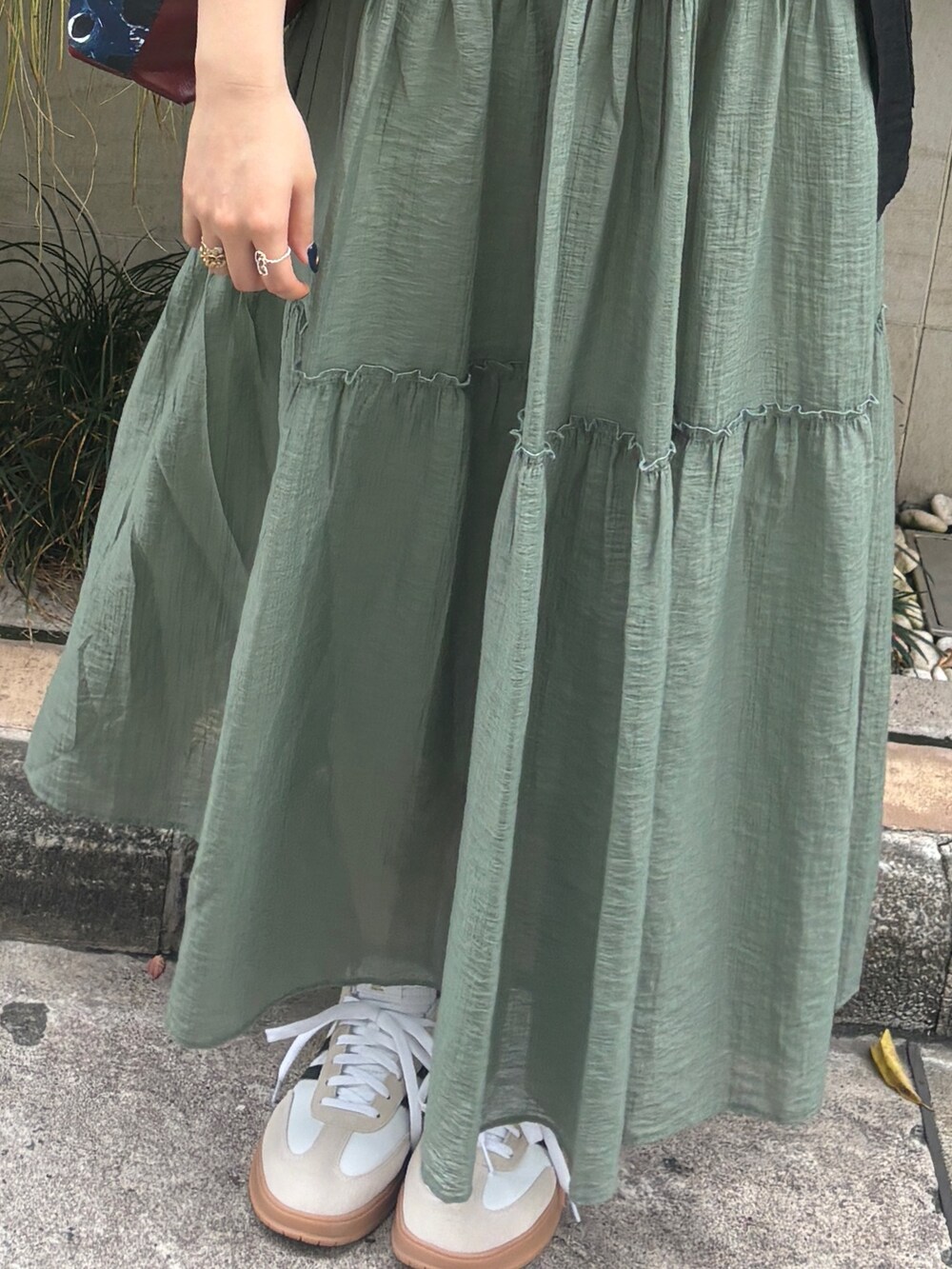 グリーン系のワンピース、ブラック系のテーラードジャケットを着用したレディースの夏コーディネートの4枚目の写真