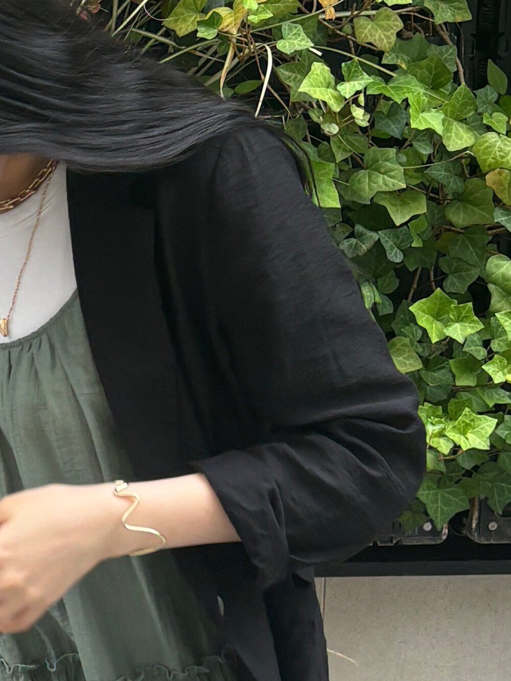 グリーン系のワンピース、ブラック系のテーラードジャケットを着用したレディースの夏コーディネートの7枚目の写真