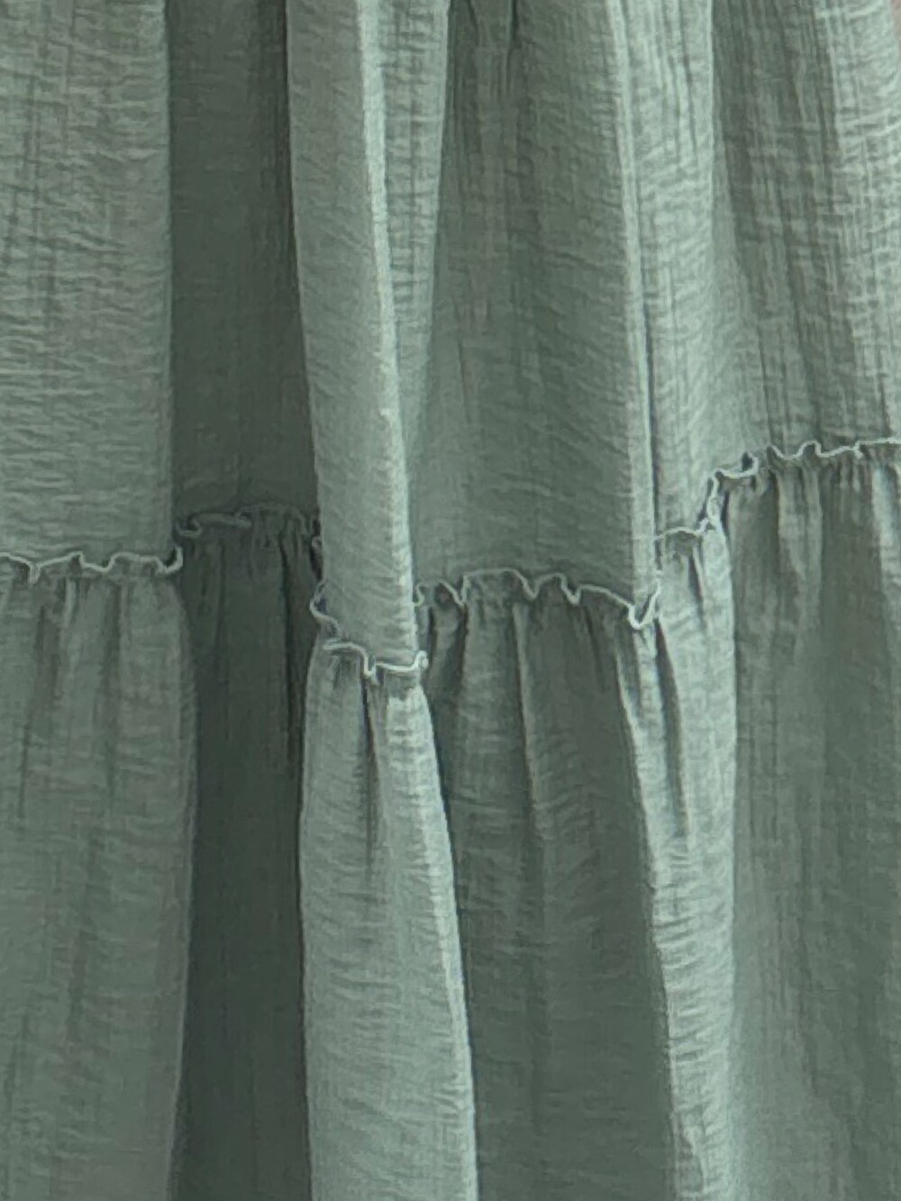 グリーン系のワンピース、ブラック系のテーラードジャケットを着用したレディースの夏コーディネートの9枚目の写真