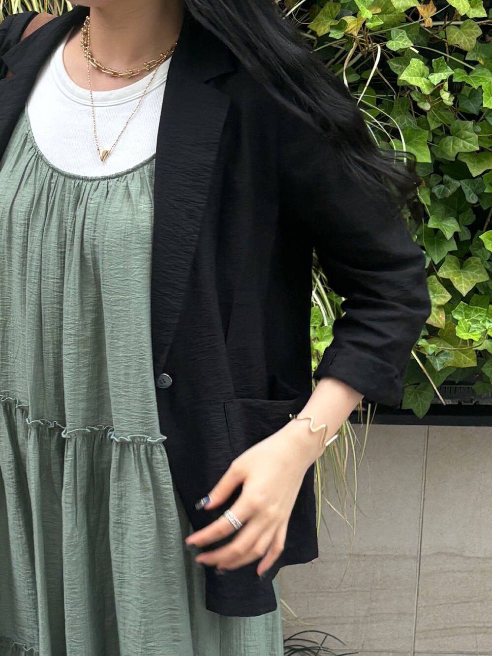 グリーン系のワンピース、ブラック系のテーラードジャケットを着用したレディースの夏コーディネートの3枚目の写真