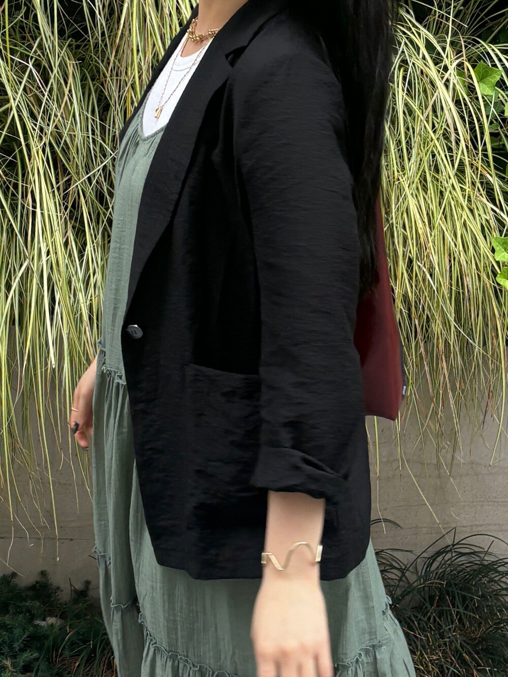 グリーン系のワンピース、ブラック系のテーラードジャケットを着用したレディースの夏コーディネートの6枚目の写真