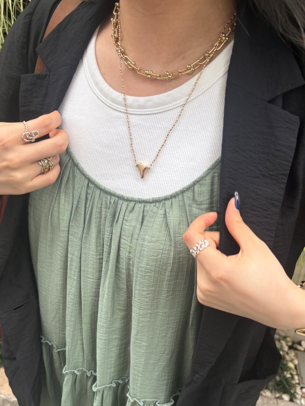 グリーン系のワンピース、ブラック系のテーラードジャケットを着用したレディースの夏コーディネートの2枚目の写真