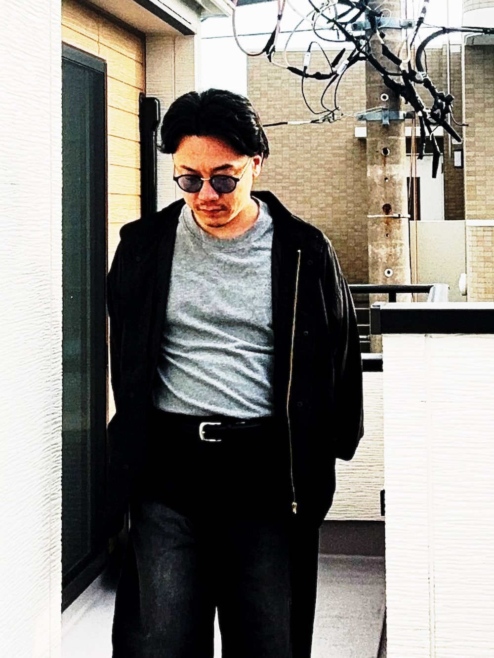 ブラック系のデニムパンツ、グレー系のTシャツ/カットソー、ブラック系のブルゾンを着用したメンズの秋コーディネートの2枚目の写真