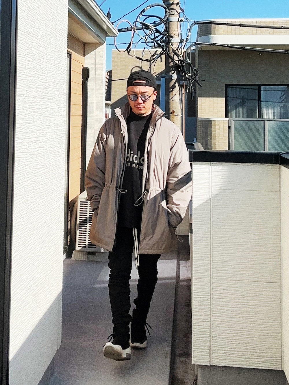 ブラック系のスウェット、ベージュ系のその他アウター、ブラック系のパンツを着用したメンズの冬コーディネートの3枚目の写真