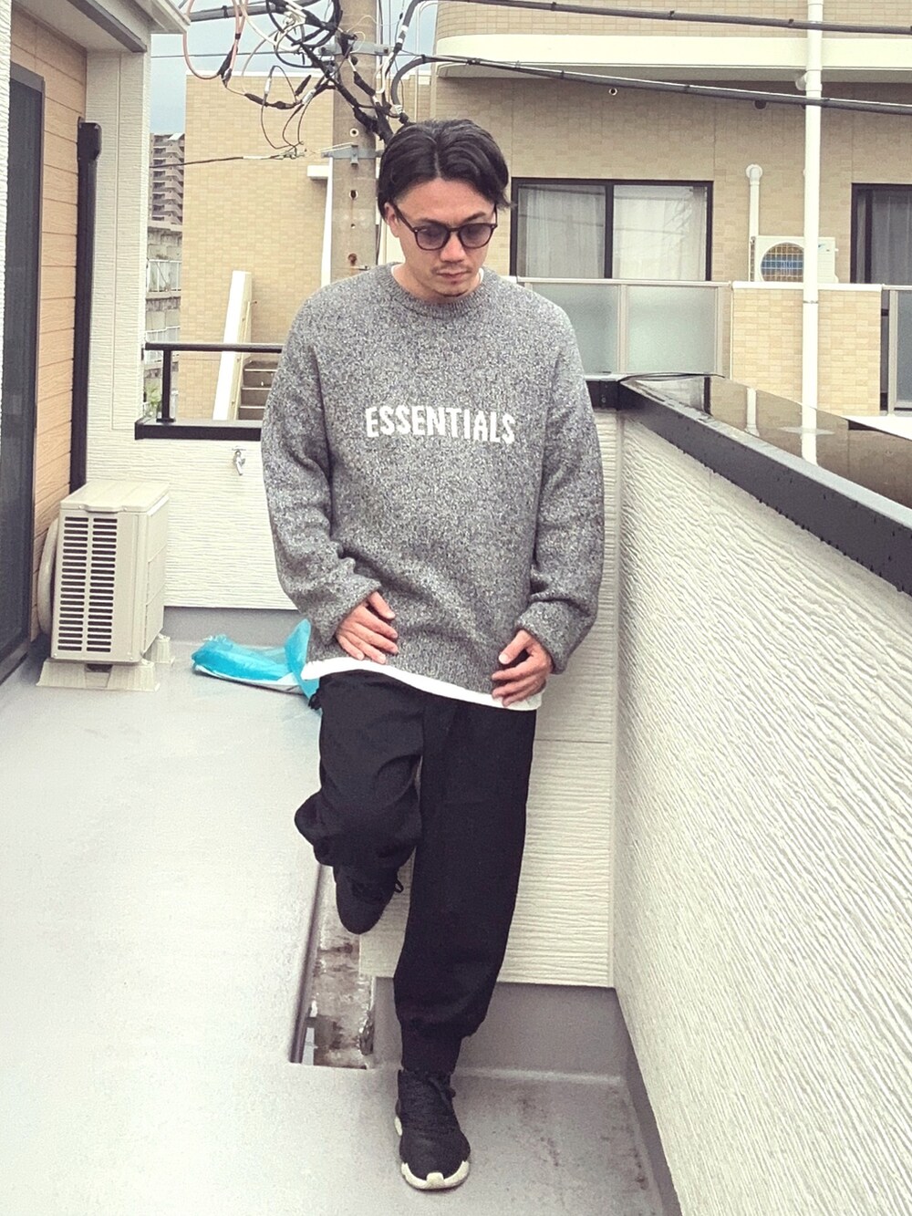 グレー系のニット/セーター、ブラック系のその他パンツ、ホワイト系のTシャツ/カットソーを着用したメンズの秋コーディネートの3枚目の写真