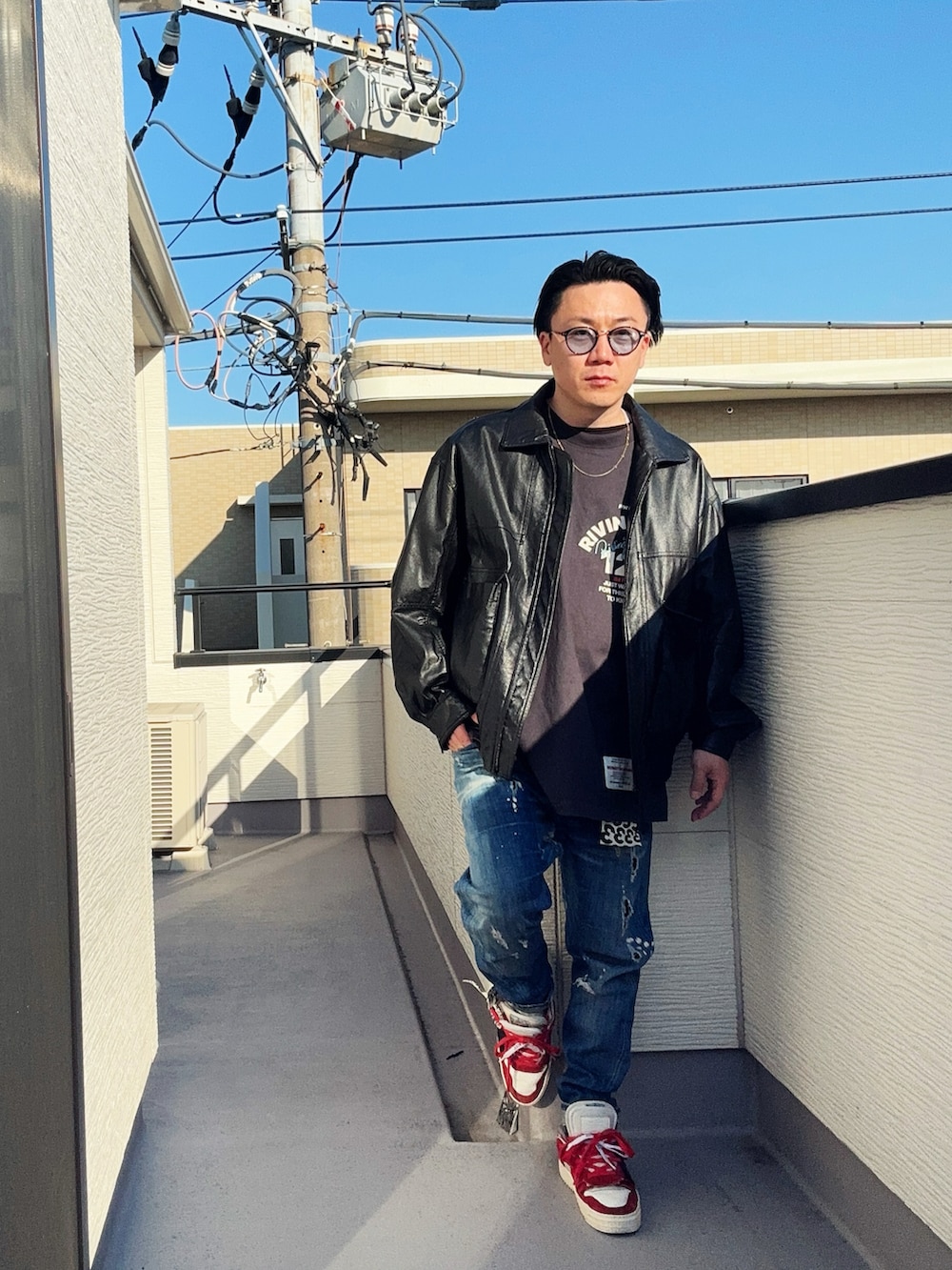 ブラック系のブルゾン、ブラック系のTシャツ/カットソー、ブルー系のデニムパンツを着用したメンズの冬コーディネートの3枚目の写真