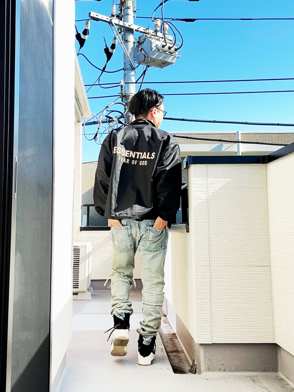 ブラック系のナイロンジャケット、グレー系のTシャツ/カットソー、ブルー系のデニムパンツを着用したメンズの秋コーディネートの4枚目の写真