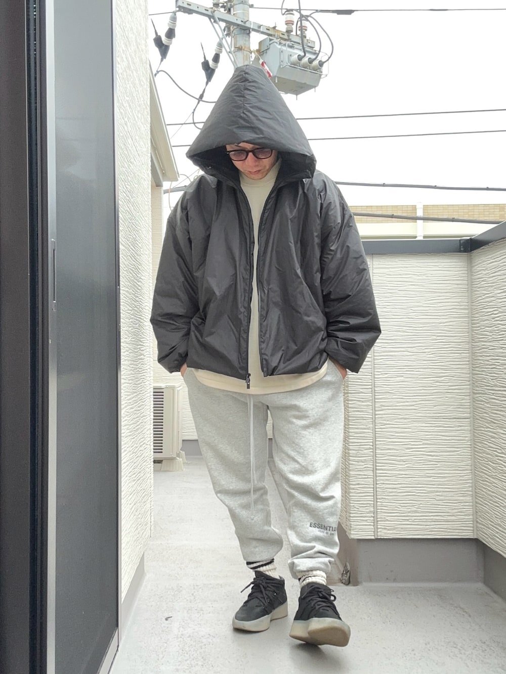 ベージュ系のスウェット、ブラック系のジャケット/アウター、グレー系のスウェットパンツを着用したメンズの冬コーディネートの2枚目の写真