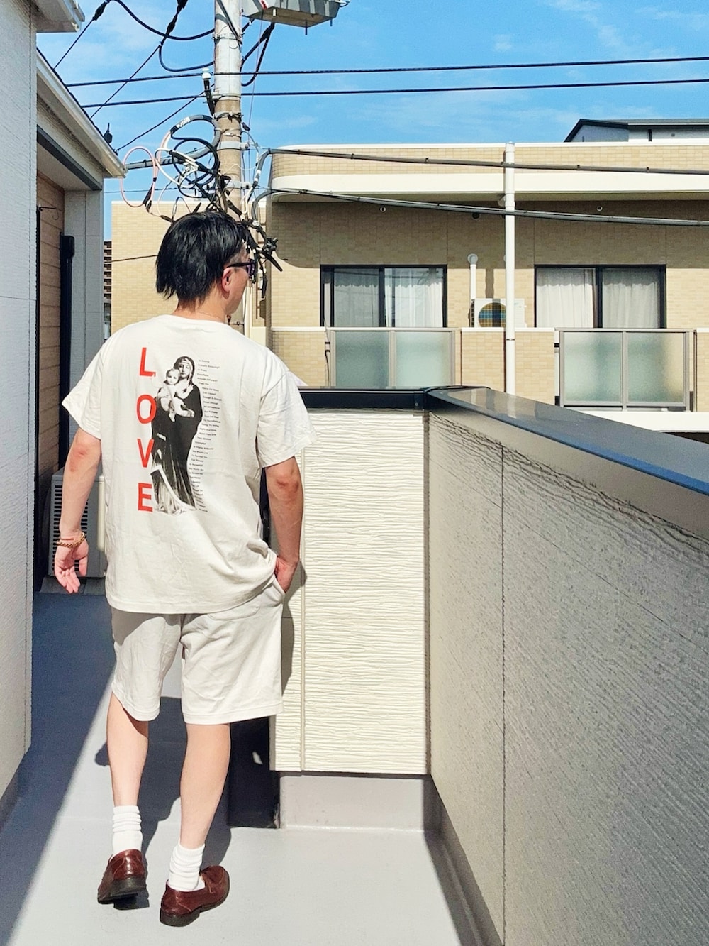 ホワイト系のTシャツ/カットソー、ホワイト系のパンツ、ブラウン系のローファーを着用したメンズの春コーディネートの3枚目の写真