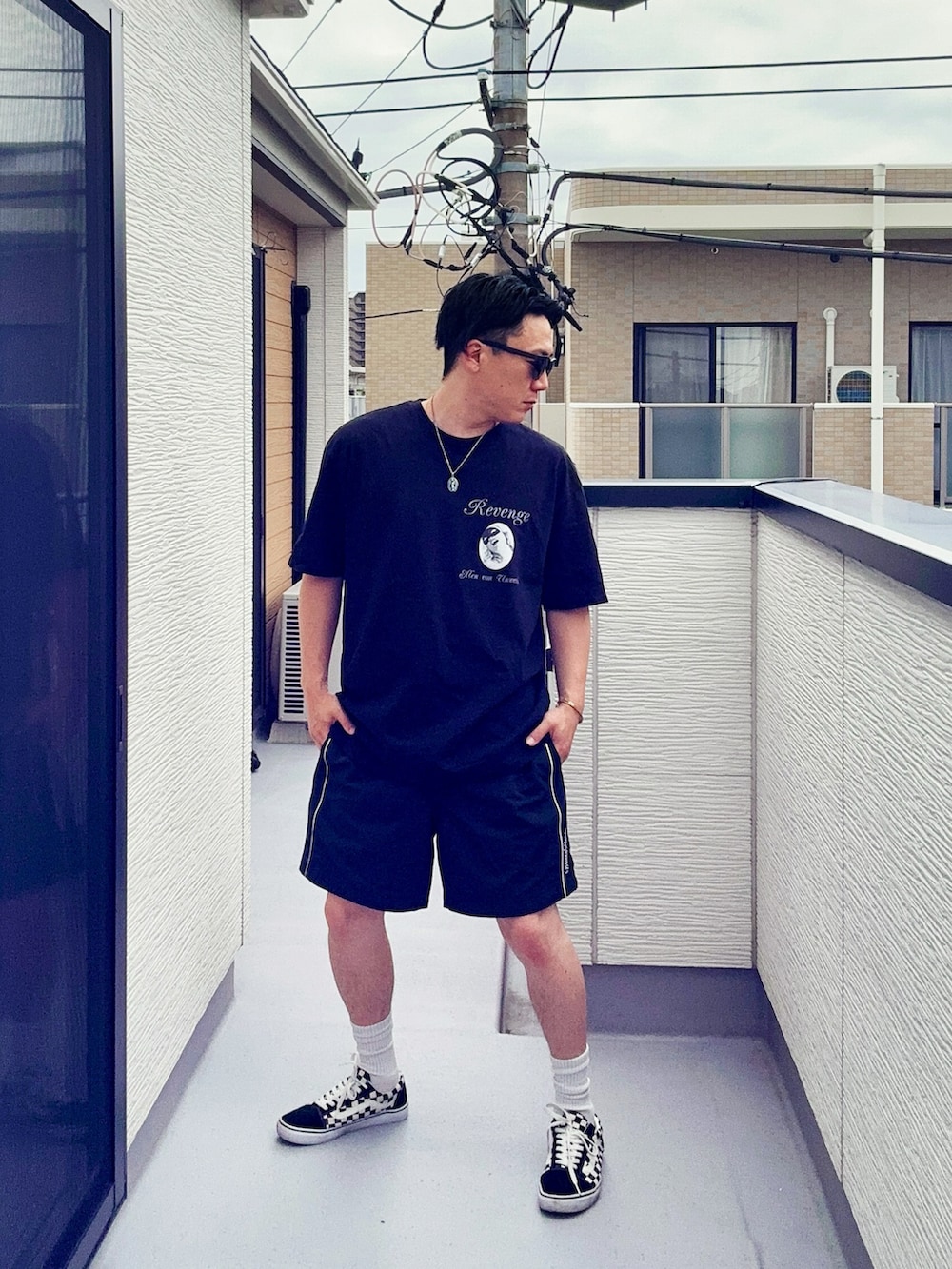 ブラック系のスニーカー、ブラック系のTシャツ/カットソー、ブラック系のパンツを着用したメンズの春コーディネートの2枚目の写真