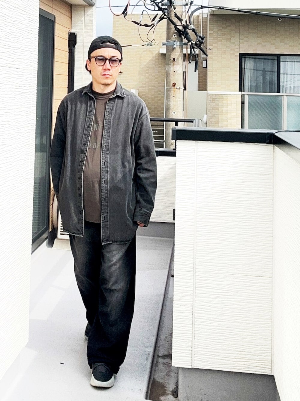 ブラック系のTシャツ/カットソー、ブラック系のシャツ/ブラウス、ブラック系のデニムパンツを着用したメンズの秋コーディネートの2枚目の写真