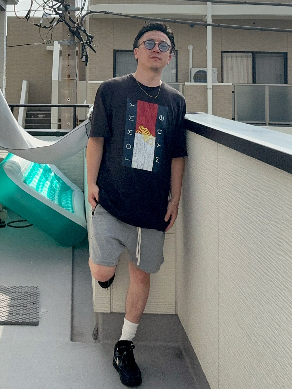 ブラック系のTシャツ/カットソー、グレー系のパンツ、ブラック系のスニーカーを着用したメンズの夏コーディネートの2枚目の写真