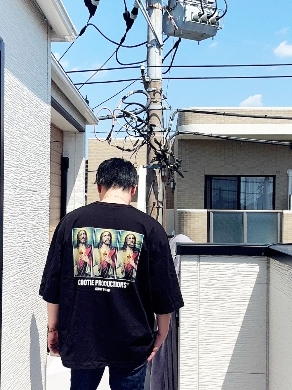 ブラック系のTシャツ/カットソー、ブルー系のデニムパンツ、ブラック系のブーツを着用したメンズの春コーディネートの2枚目の写真
