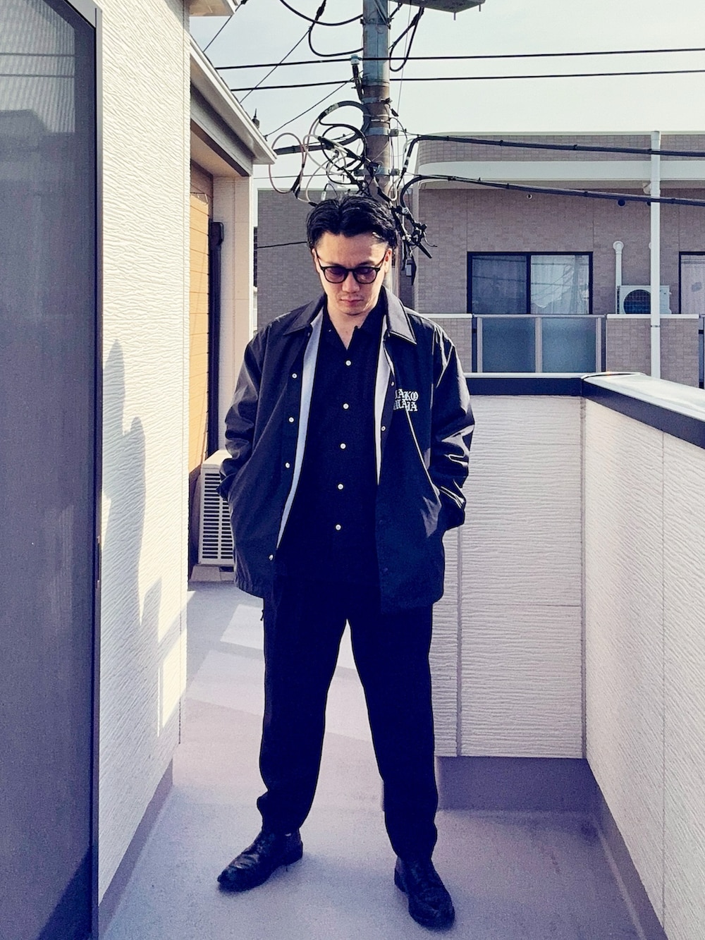 ブラック系のスラックス、ブラック系のシャツ/ブラウス、ブラック系のジャケット/アウターを着用したメンズの春コーディネートの2枚目の写真