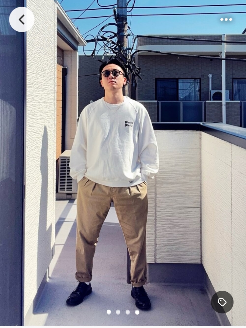 グリーン系のチノパンツ、ホワイト系のスウェット、ブラック系のドレスシューズを着用したメンズの春コーディネートの2枚目の写真