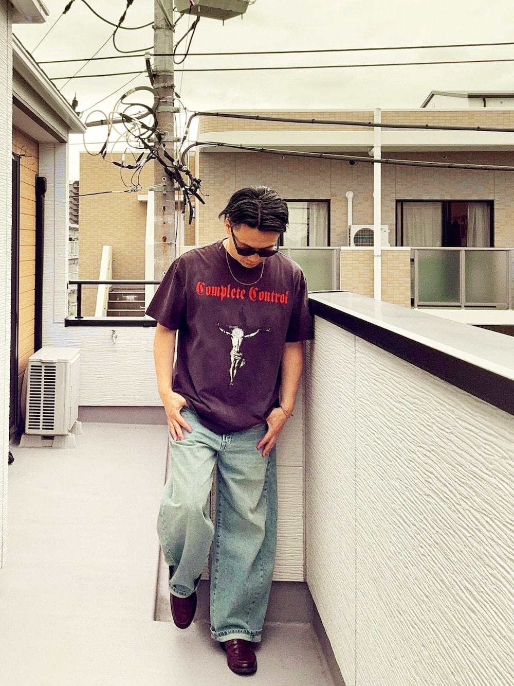 ブラック系のTシャツ/カットソー、ブルー系のデニムパンツ、ブラウン系のローファーを着用したメンズの春コーディネートの2枚目の写真
