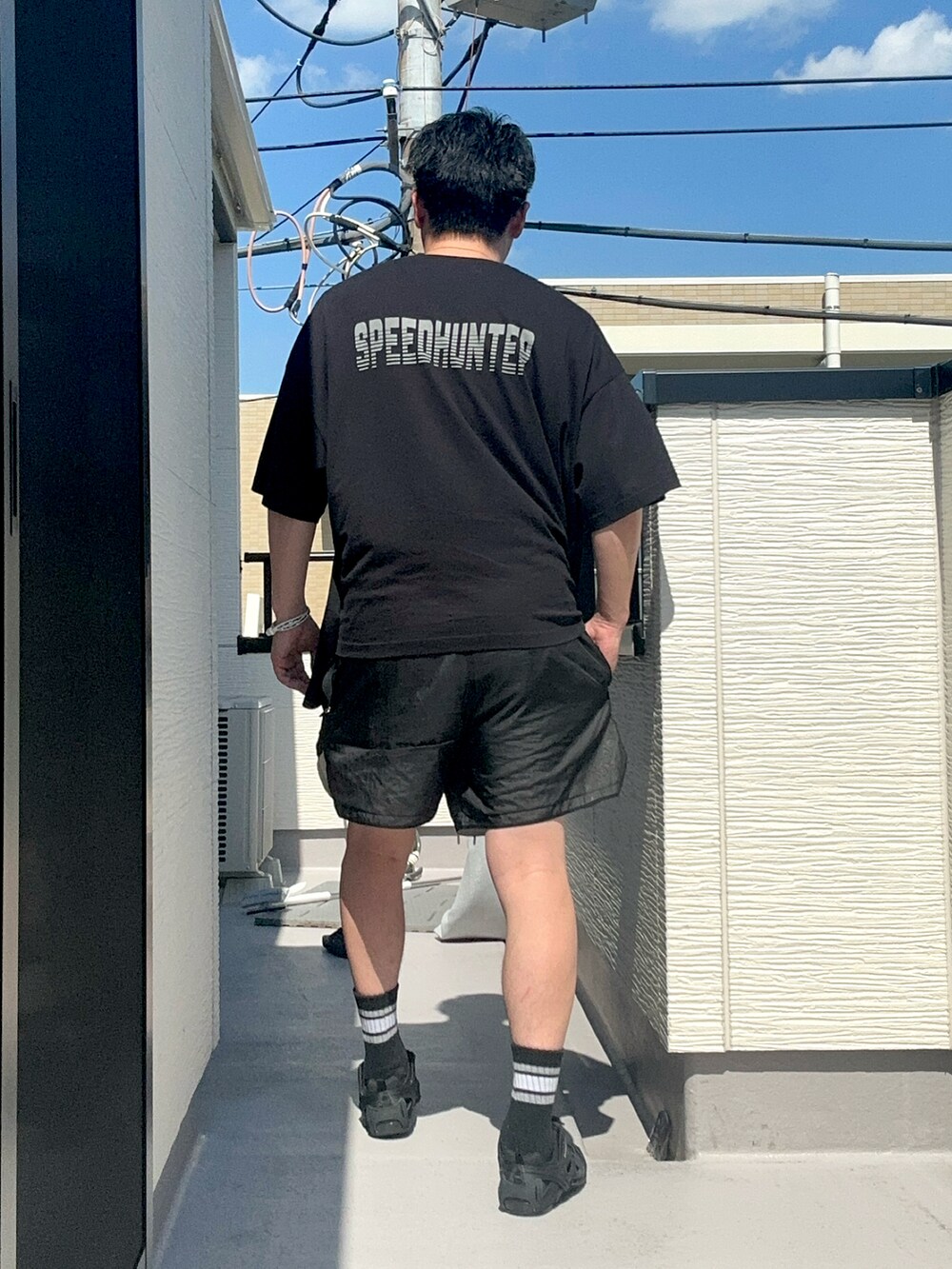ブラック系のTシャツ/カットソー、ブラック系のパンツ、ブラック系のシューズを着用したメンズの夏コーディネートの5枚目の写真