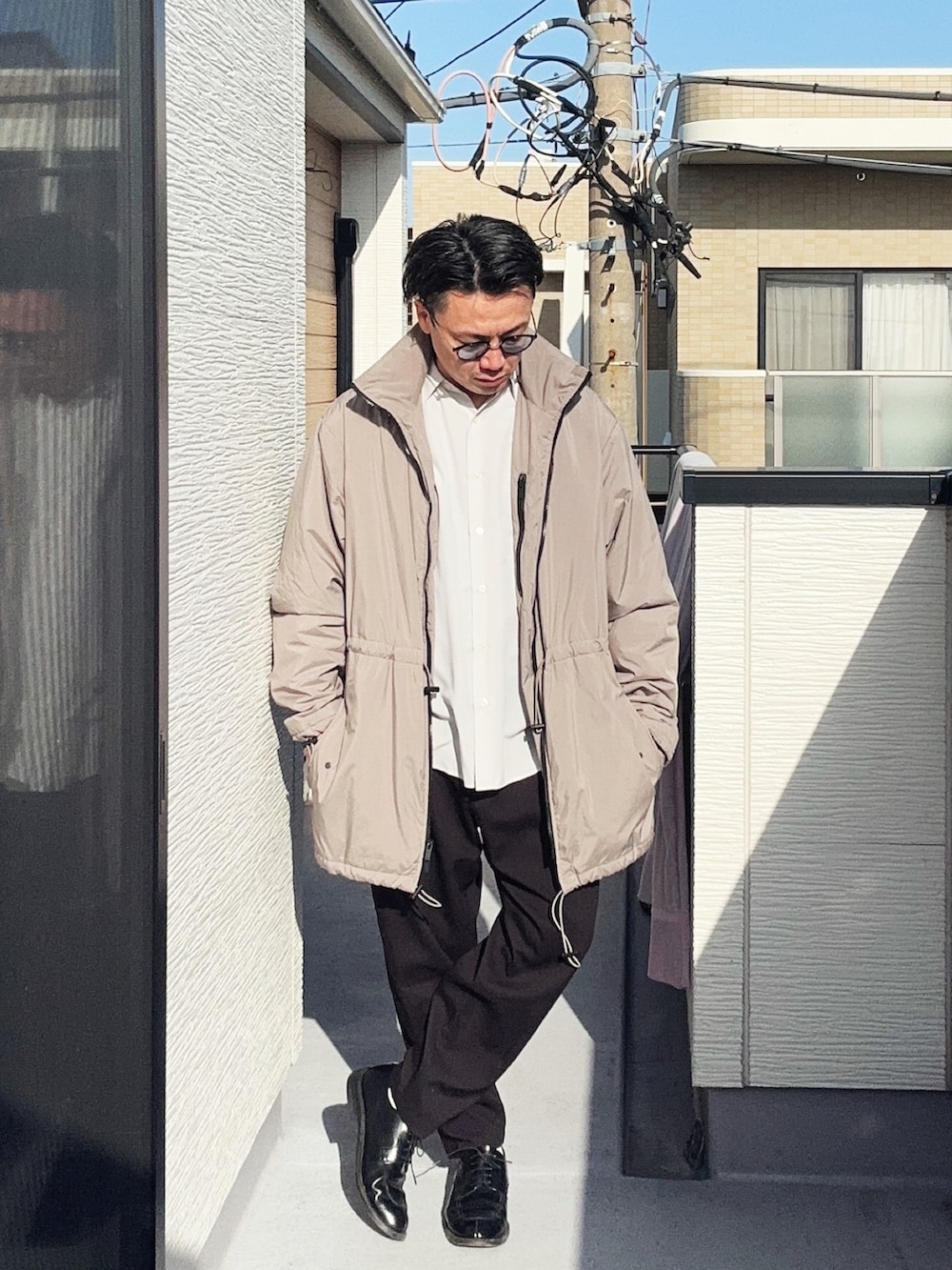 ベージュ系のその他アウター、ブラック系のスラックス、ホワイト系のシャツ/ブラウスを着用したメンズの春コーディネートの3枚目の写真