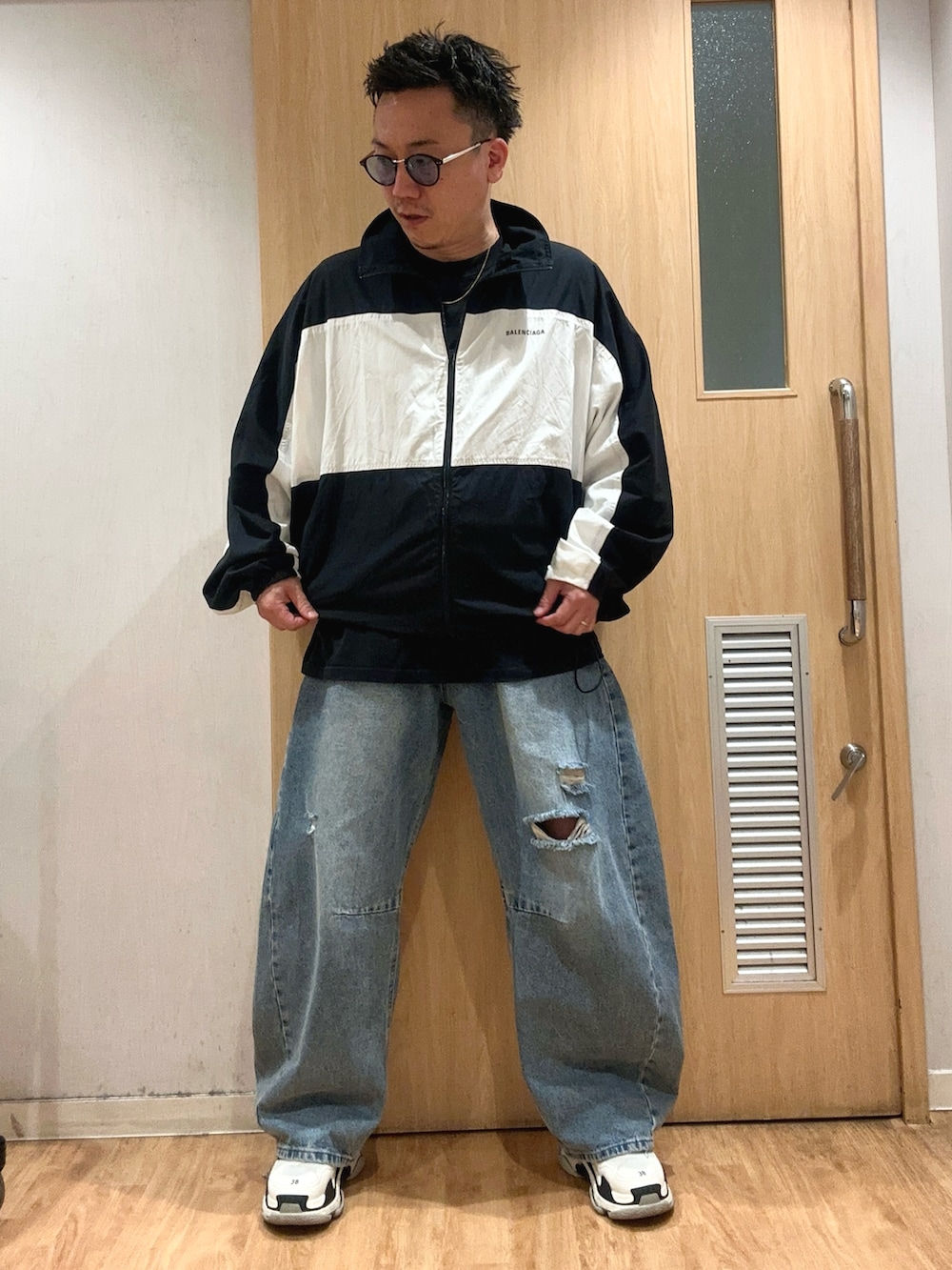 ブルー系のデニムパンツ、ブラック系のTシャツ/カットソー、ブラック系のナイロンジャケットを着用したメンズの秋コーディネートの5枚目の写真