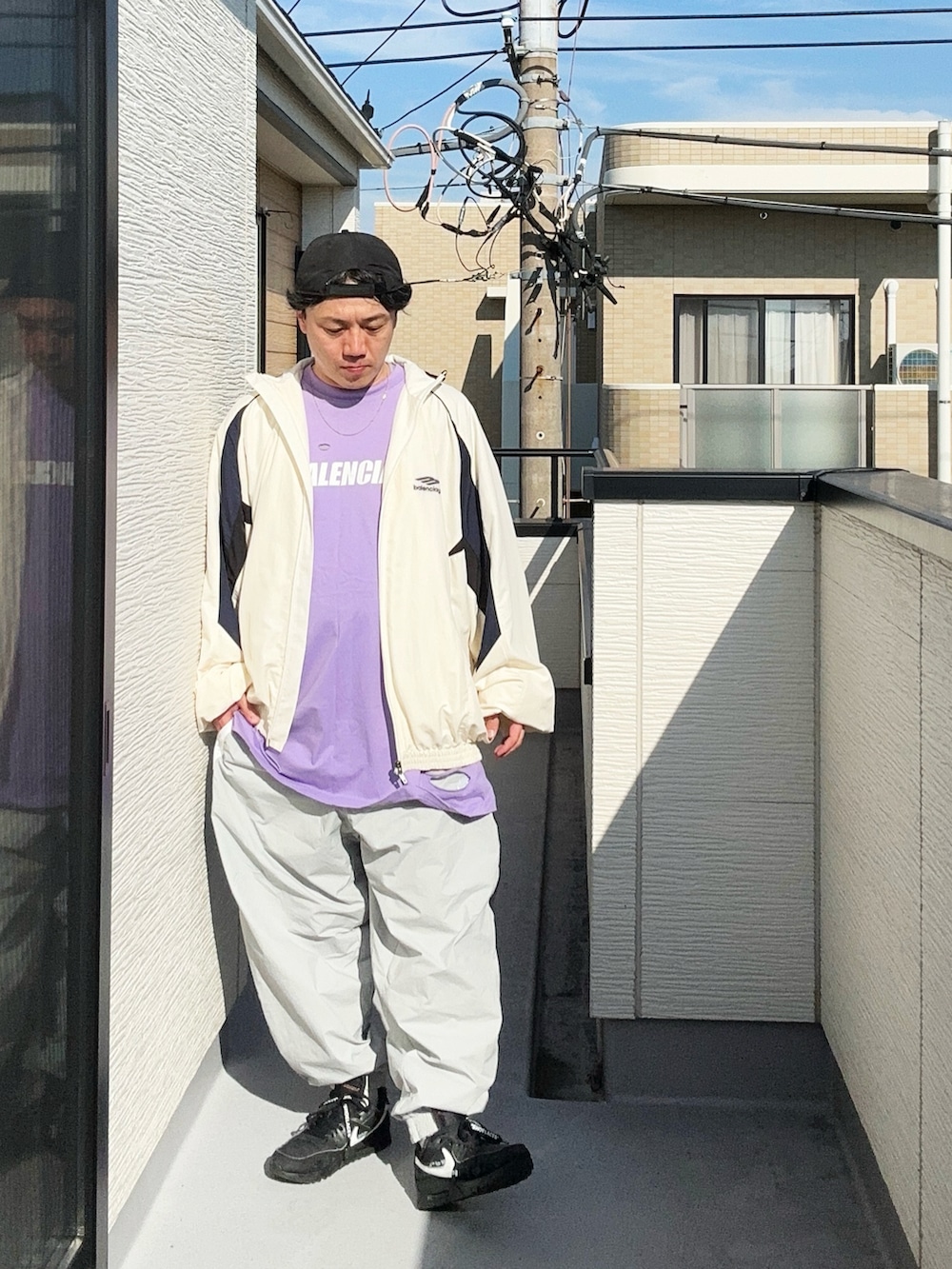 グレー系のその他パンツ、パープル系のTシャツ/カットソー、ホワイト系のナイロンジャケットを着用したメンズの秋コーディネートの5枚目の写真