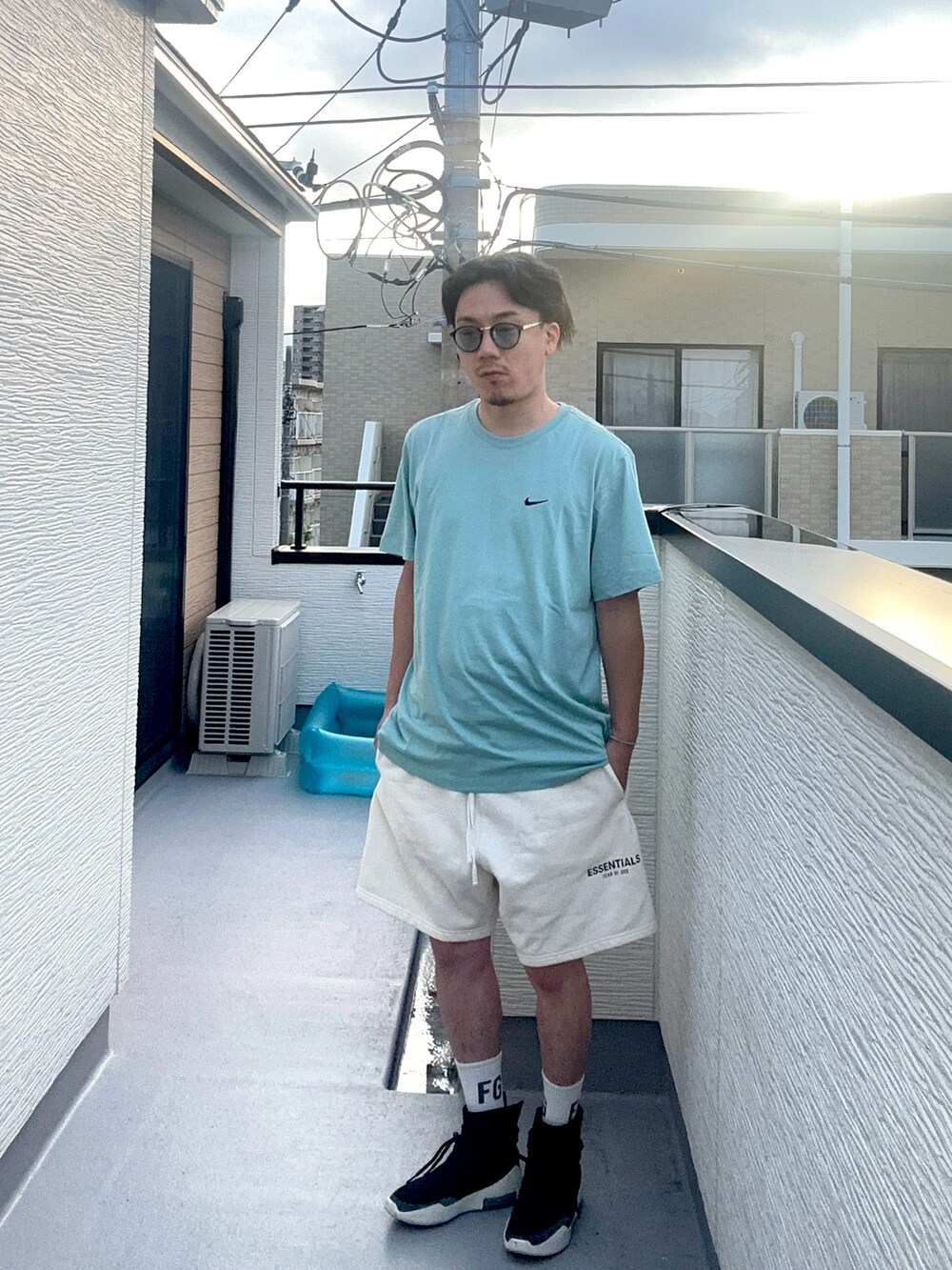 ブルー系のTシャツ/カットソー、ホワイト系のスウェットパンツ、ブラック系のスニーカーを着用したメンズの夏コーディネートの3枚目の写真