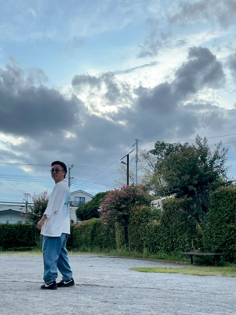 ホワイト系のTシャツ/カットソー、ブルー系のデニムパンツ、ブラック系のスニーカーを着用したメンズの夏コーディネートの5枚目の写真