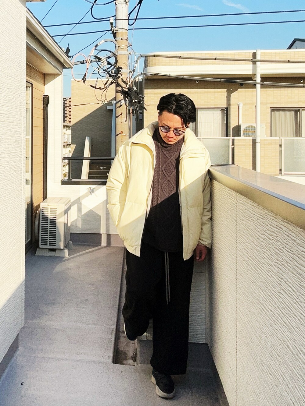 ブラック系のニット/セーター、ベージュ系のダウンジャケット/コート、ブラック系のスウェットパンツを着用したメンズの冬コーディネートの3枚目の写真