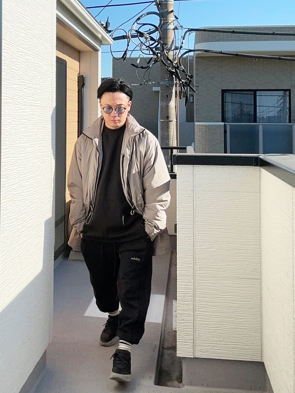 ブラック系のスニーカー、ブラック系のスウェットパンツ、ブラック系のスウェットを着用したメンズの冬コーディネートの2枚目の写真