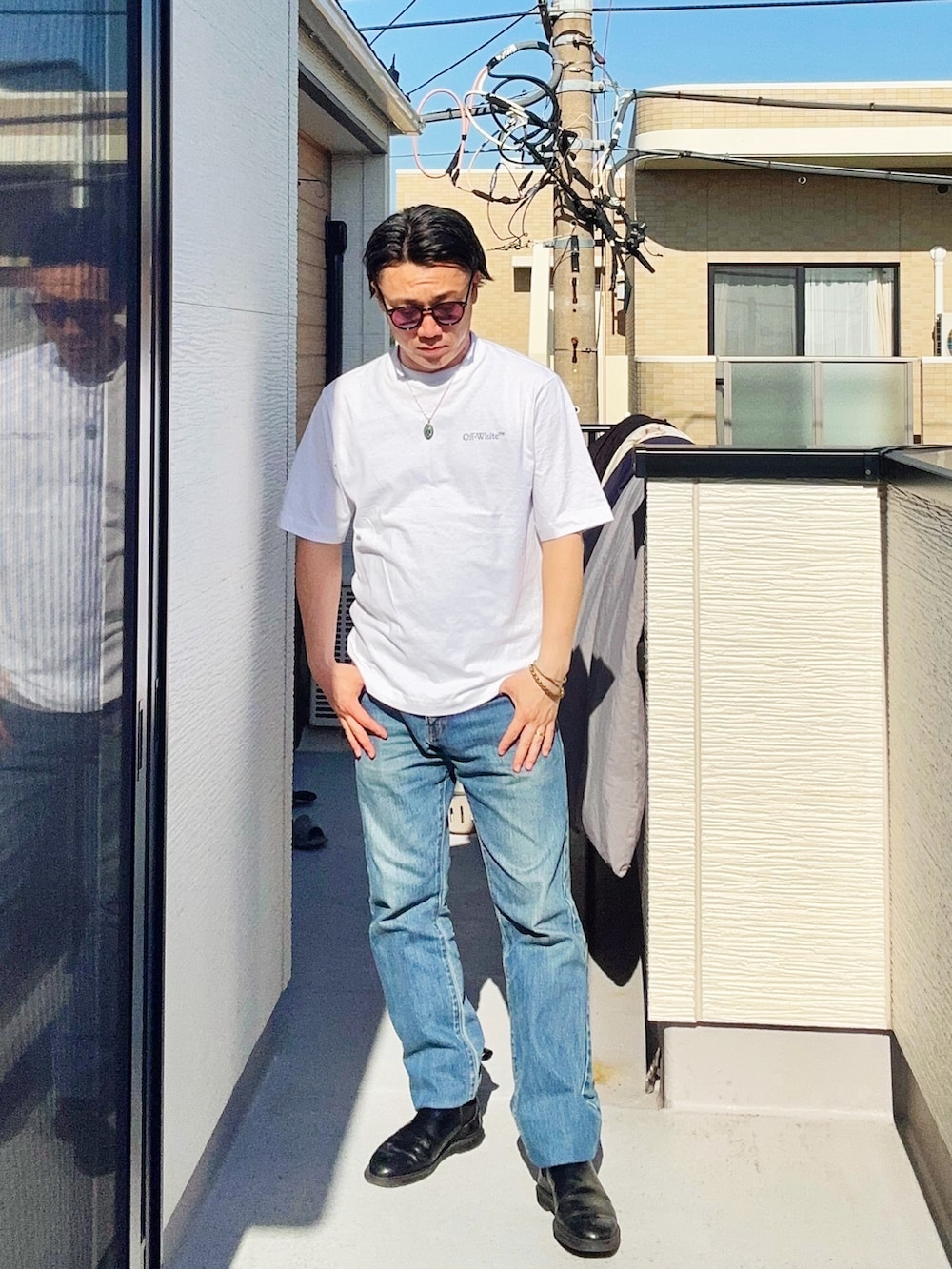 ブルー系のデニムパンツ、ホワイト系のTシャツ/カットソー、ブラック系のブーツを着用したメンズの春コーディネートの2枚目の写真