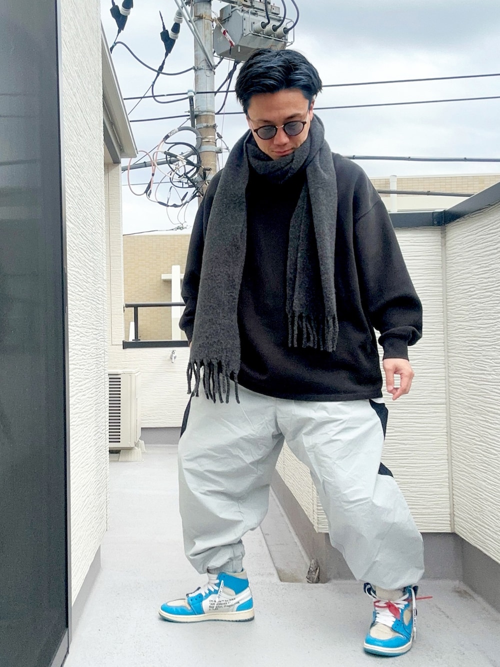 ブラック系のスウェット、グレー系のその他パンツ、ブルー系のスニーカーを着用したメンズの冬コーディネートの2枚目の写真