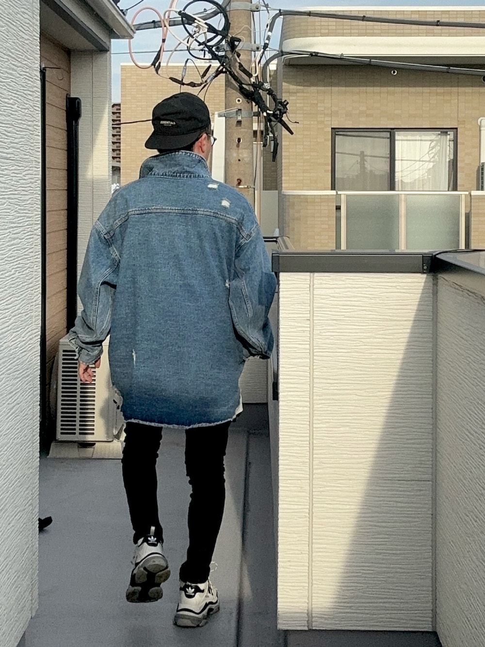 ホワイト系のTシャツ/カットソー、ブルー系のデニムジャケット、ブラック系のデニムパンツを着用したメンズの秋コーディネートの5枚目の写真