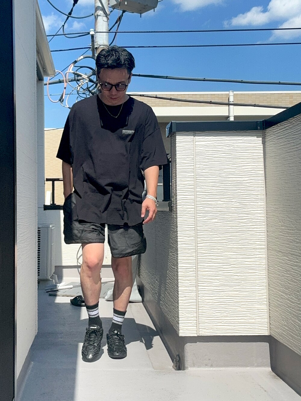 ブラック系のTシャツ/カットソー、ブラック系のパンツ、ブラック系のシューズを着用したメンズの夏コーディネートの2枚目の写真
