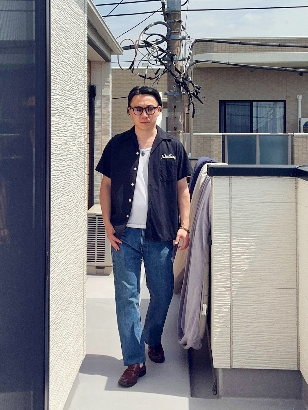 ブルー系のデニムパンツ、ホワイト系のタンクトップ、ブラック系のシャツ/ブラウスを着用したメンズの春コーディネートの2枚目の写真