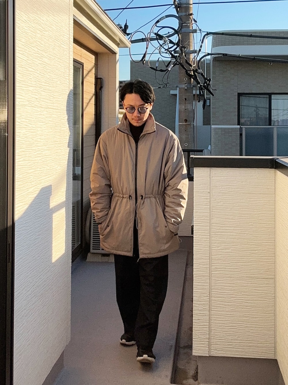 ベージュ系のその他アウター、ブルー系のスラックス、ブラック系のスニーカーを着用したメンズの冬コーディネートの2枚目の写真