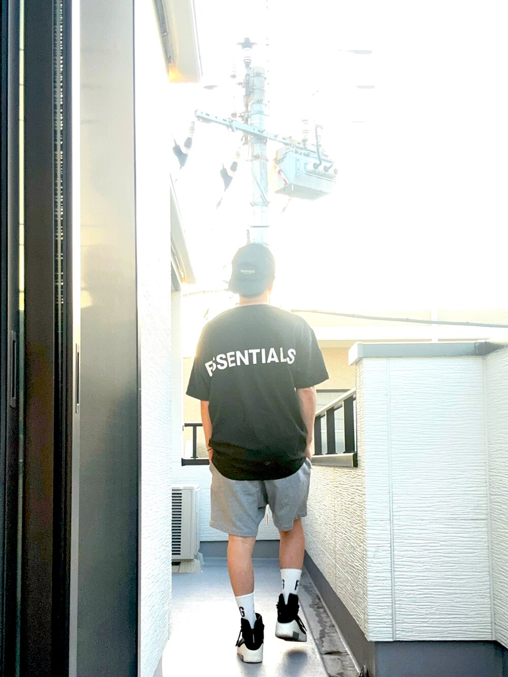 ブラック系のスニーカー、ブラック系のTシャツ/カットソー、グレー系のパンツを着用したメンズの夏コーディネートの5枚目の写真