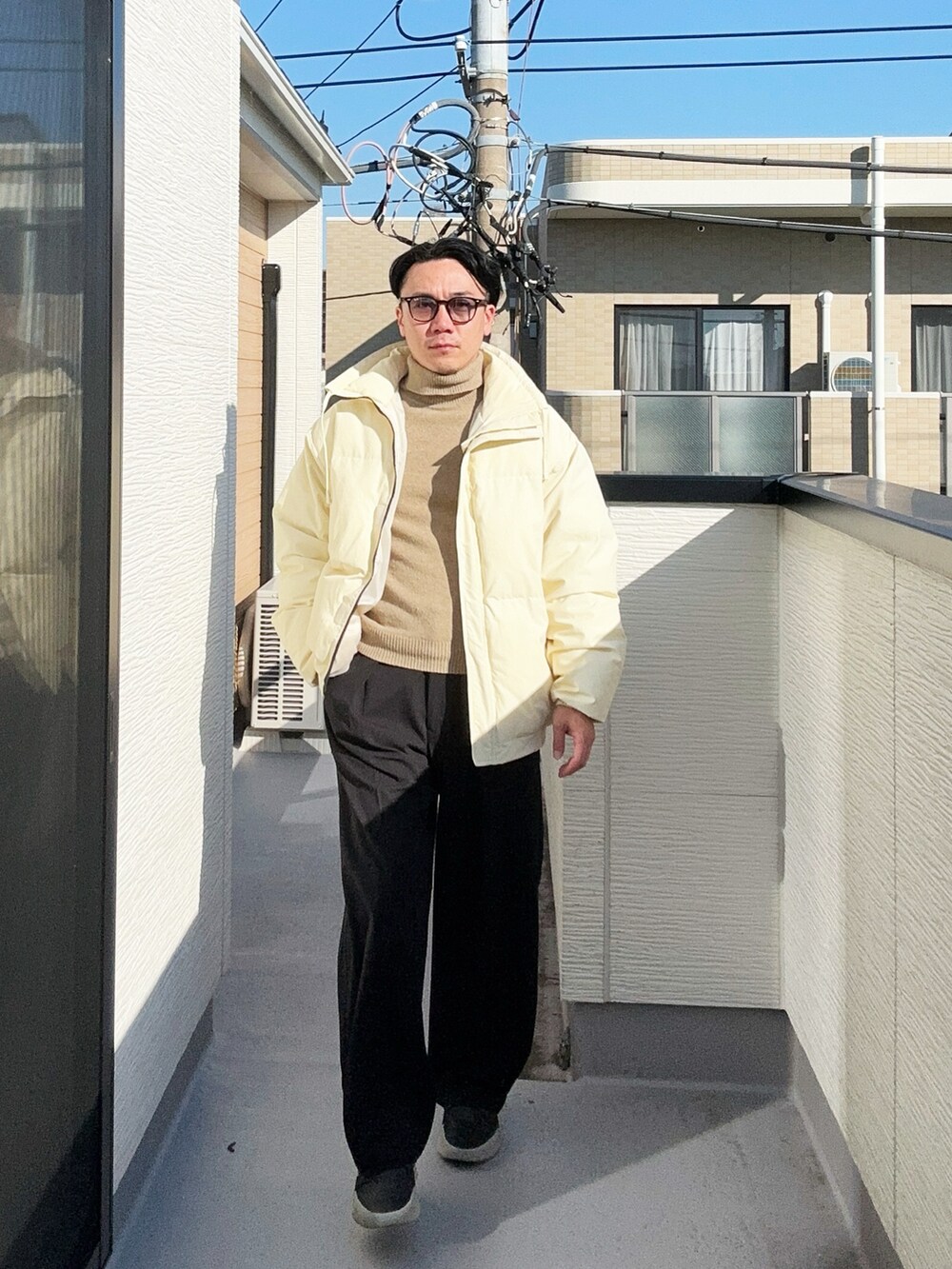 ベージュ系のニット/セーター、ベージュ系のダウンジャケット/コート、ブラック系のスラックスを着用したメンズの冬コーディネートの3枚目の写真