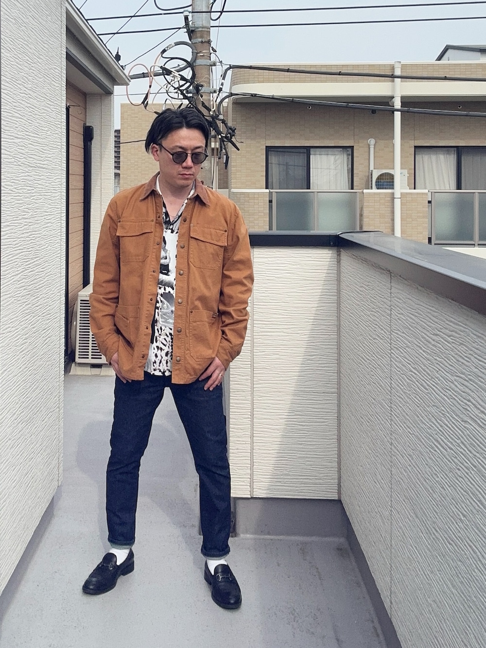 ブラック系のローファー、ホワイト系のシャツ/ブラウス、ブラウン系のカバーオールを着用したメンズの春コーディネートの3枚目の写真