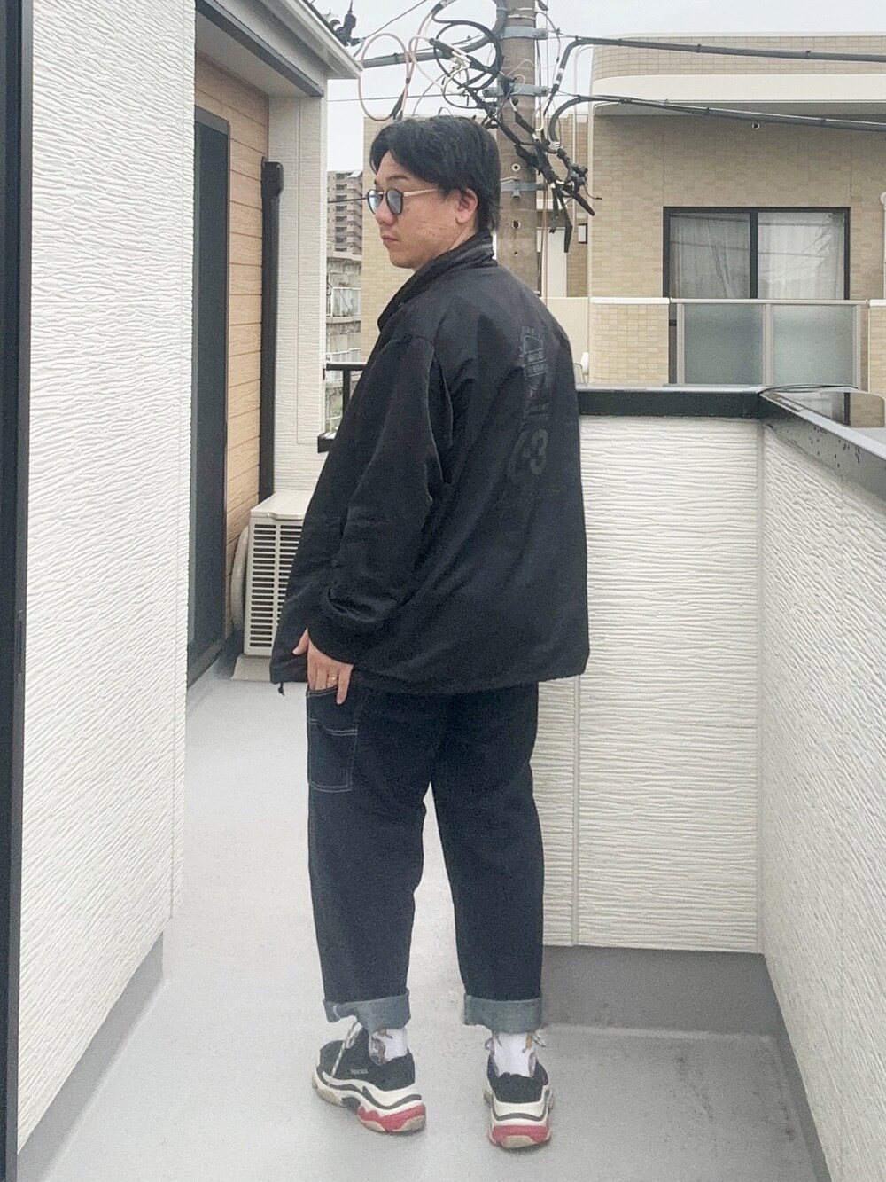 グレー系のTシャツ/カットソー、ブラック系のテーラードジャケット、ブルー系のデニムパンツを着用したメンズの秋コーディネートの3枚目の写真