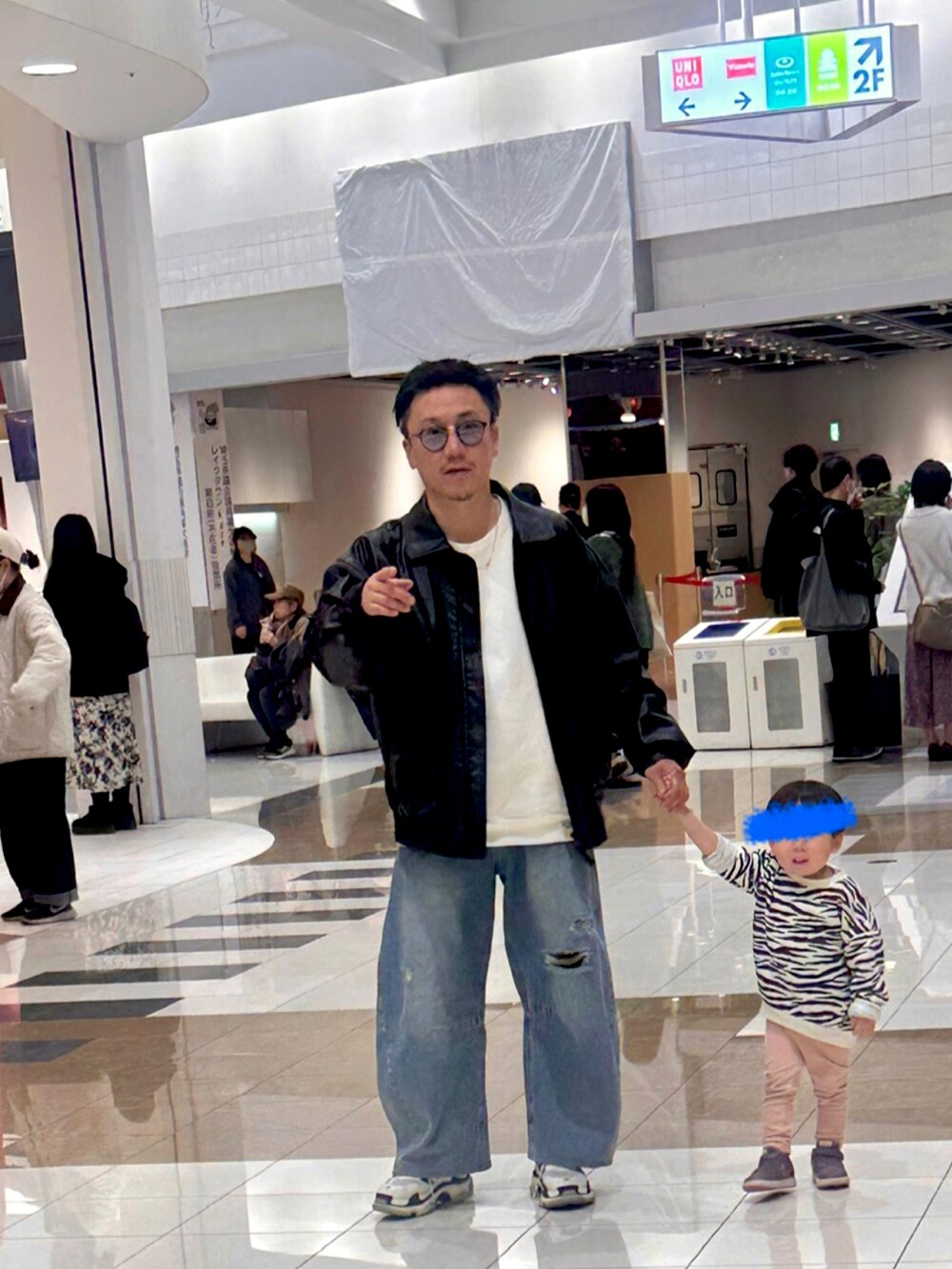 ブラック系のブルゾン、ブルー系のデニムパンツ、ホワイト系のスウェットを着用したメンズの秋コーディネートの2枚目の写真