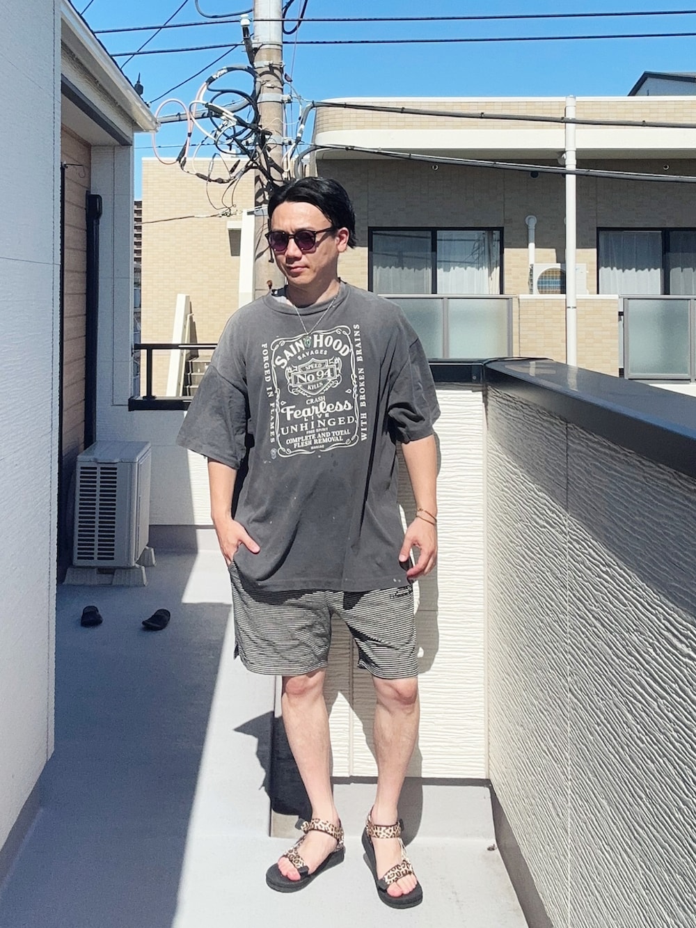 ブラック系のTシャツ/カットソー、ブラック系のパンツ、その他のサンダルを着用したメンズの夏コーディネートの3枚目の写真