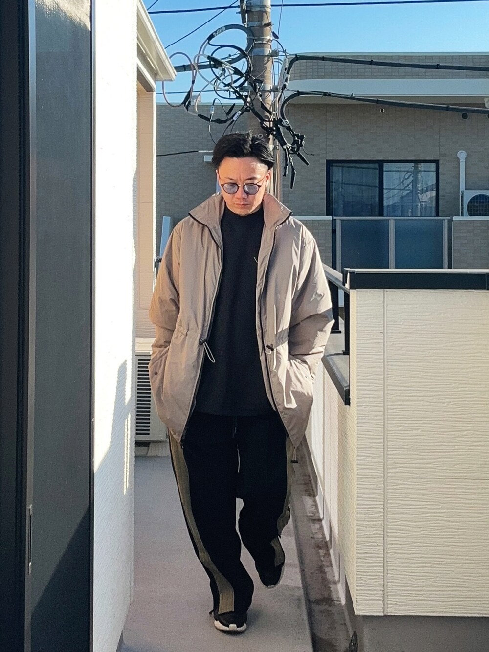 ブラック系のスウェット、ベージュ系のその他アウター、ブラック系のパンツを着用したメンズの冬コーディネートの2枚目の写真