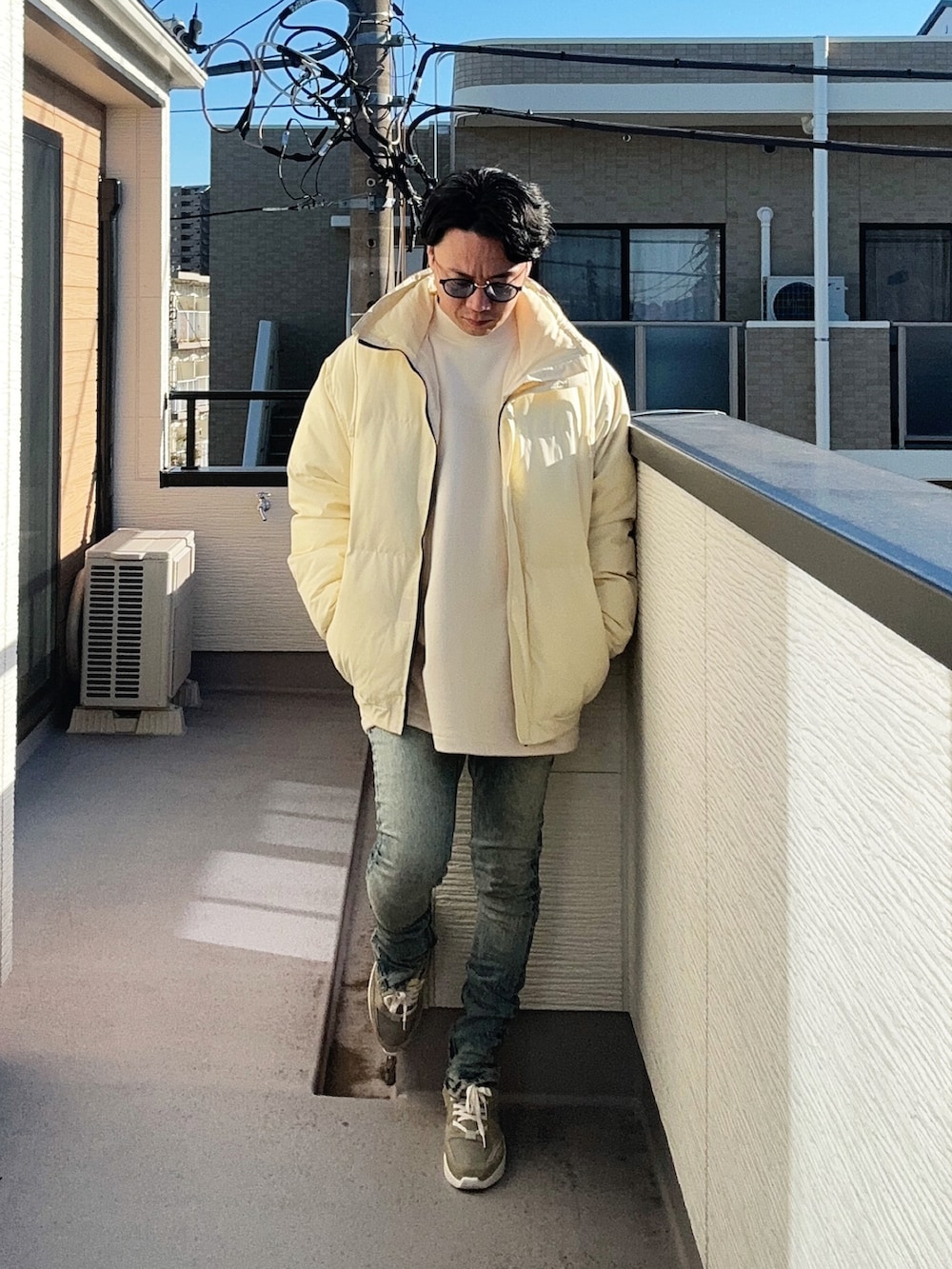 ベージュ系のダウンジャケット/コート、ベージュ系のスウェット、ブルー系のデニムパンツを着用したメンズの冬コーディネートの4枚目の写真