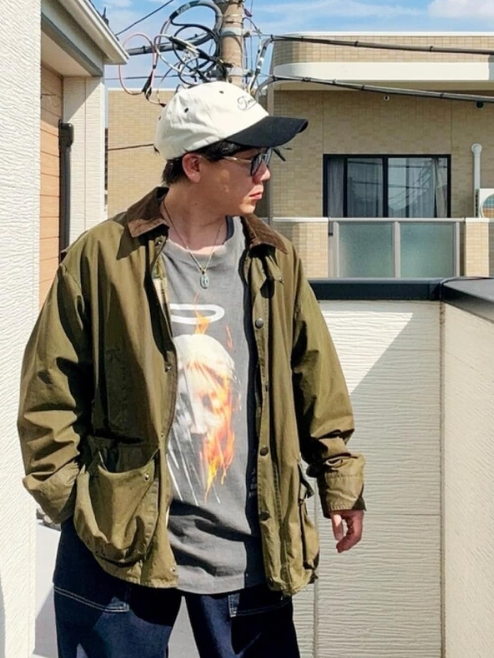 ブルー系のデニムパンツ、ブラック系のTシャツ/カットソー、ブラウン系のローファーを着用したメンズの秋コーディネートの2枚目の写真