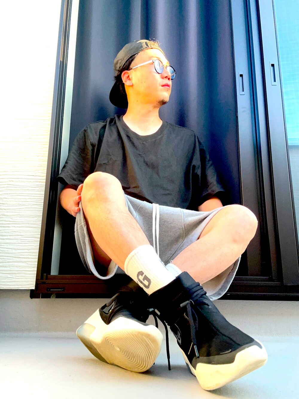 ブラック系のスニーカー、ブラック系のTシャツ/カットソー、グレー系のパンツを着用したメンズの夏コーディネートの3枚目の写真