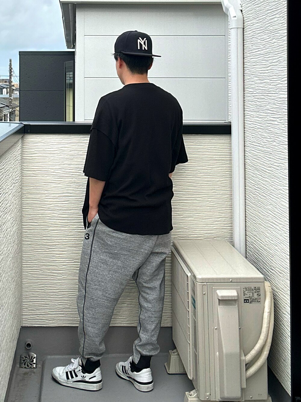 ブラック系のその他トップス、グレー系のパンツ、ホワイト系のスニーカーを着用したメンズの夏コーディネートの3枚目の写真